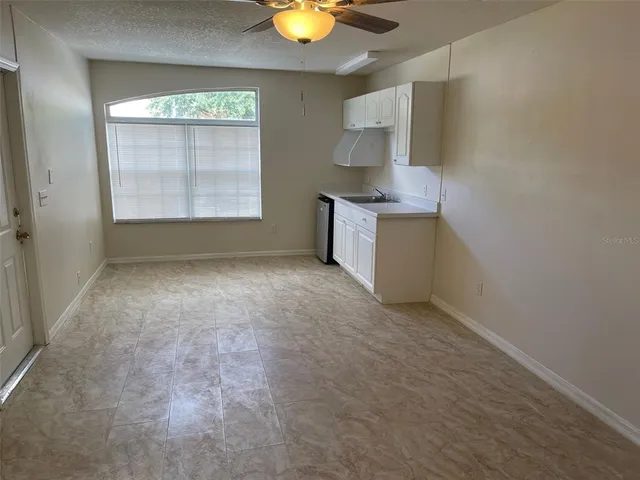 a view of an empty room with window and cabinet
