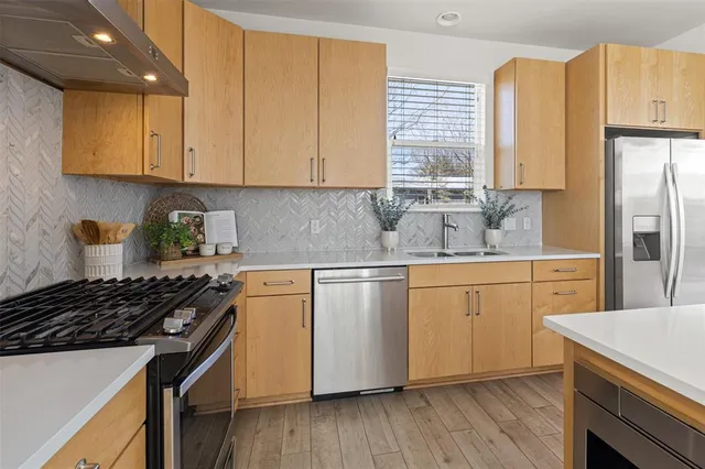 a kitchen with stainless steel appliances granite countertop a stove a sink dishwasher and a refrigerator