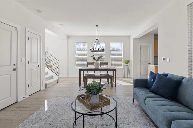 a living room with furniture a chandelier and a rug