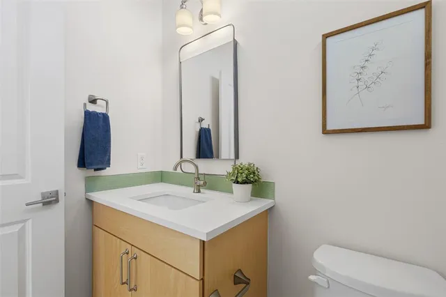 a bathroom with a sink vanity and toilet