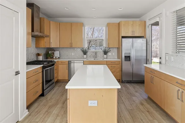 a kitchen with a refrigerator a sink dishwasher a stove with wooden floor