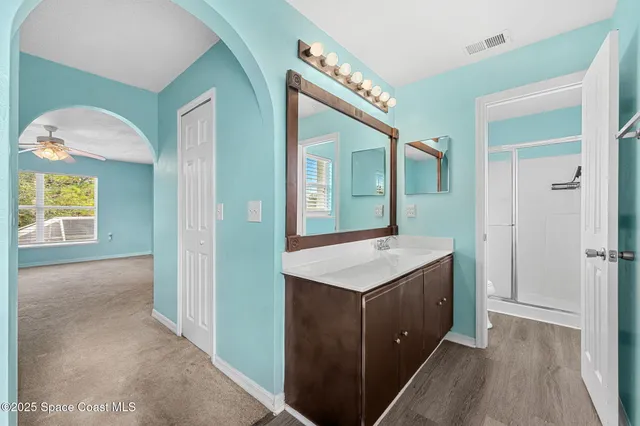 a hall with a sink a mirror and a vanity