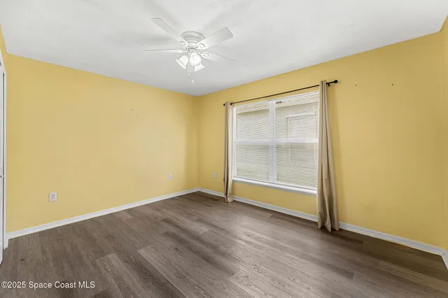 an empty room with wooden floor and door