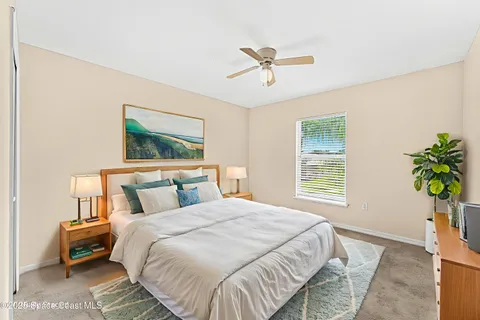 a bedroom with a bed lamp and a potted plant