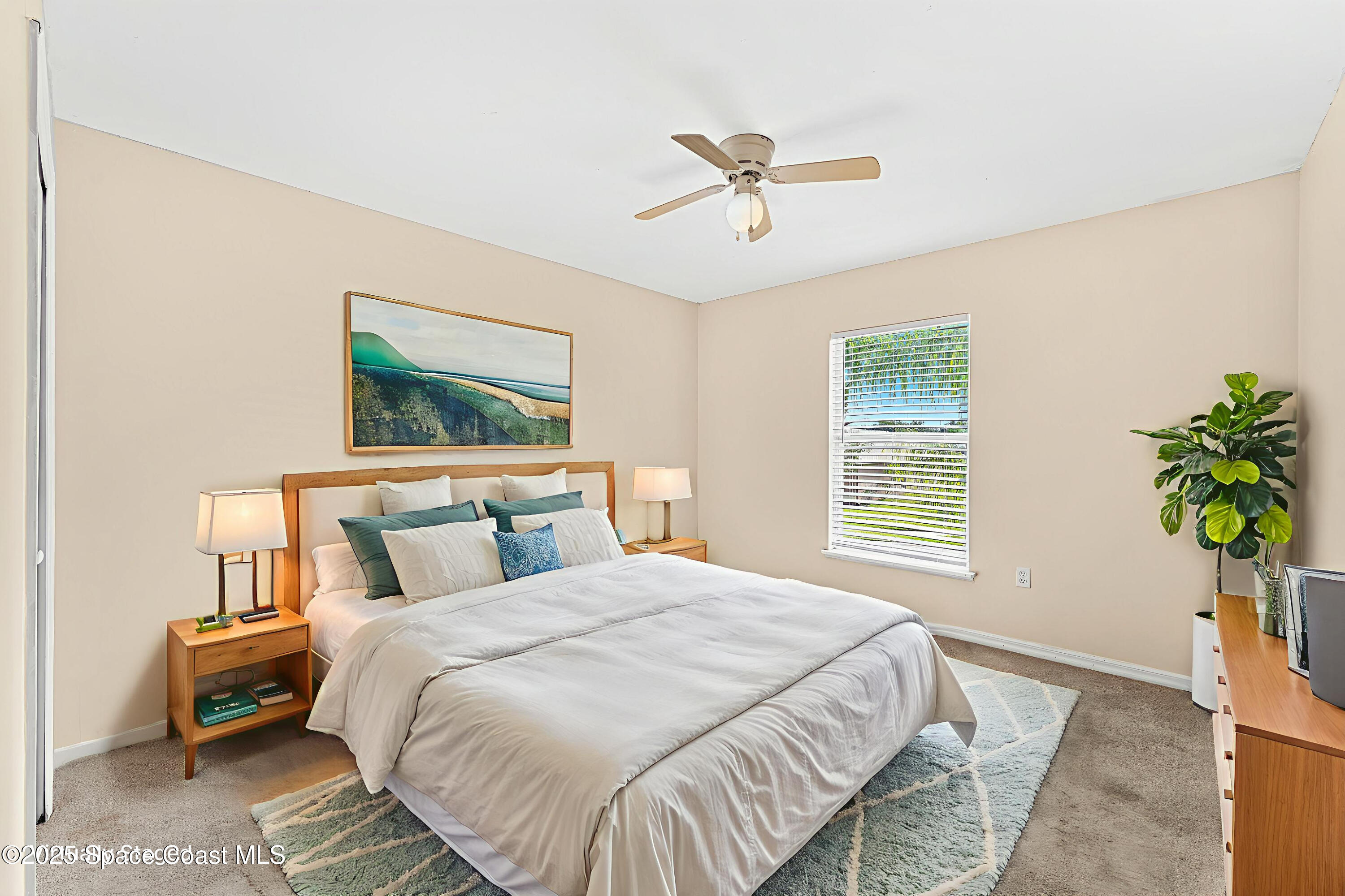 1249 White Oak Circle Melbourne, FL 32934 - Photo 16 of 34 a bedroom with a bed lamp and a potted plant
