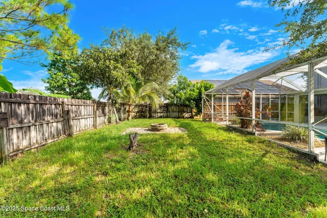 a view of a house with backyard and sitting area