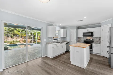 a kitchen with white cabinets and appliances