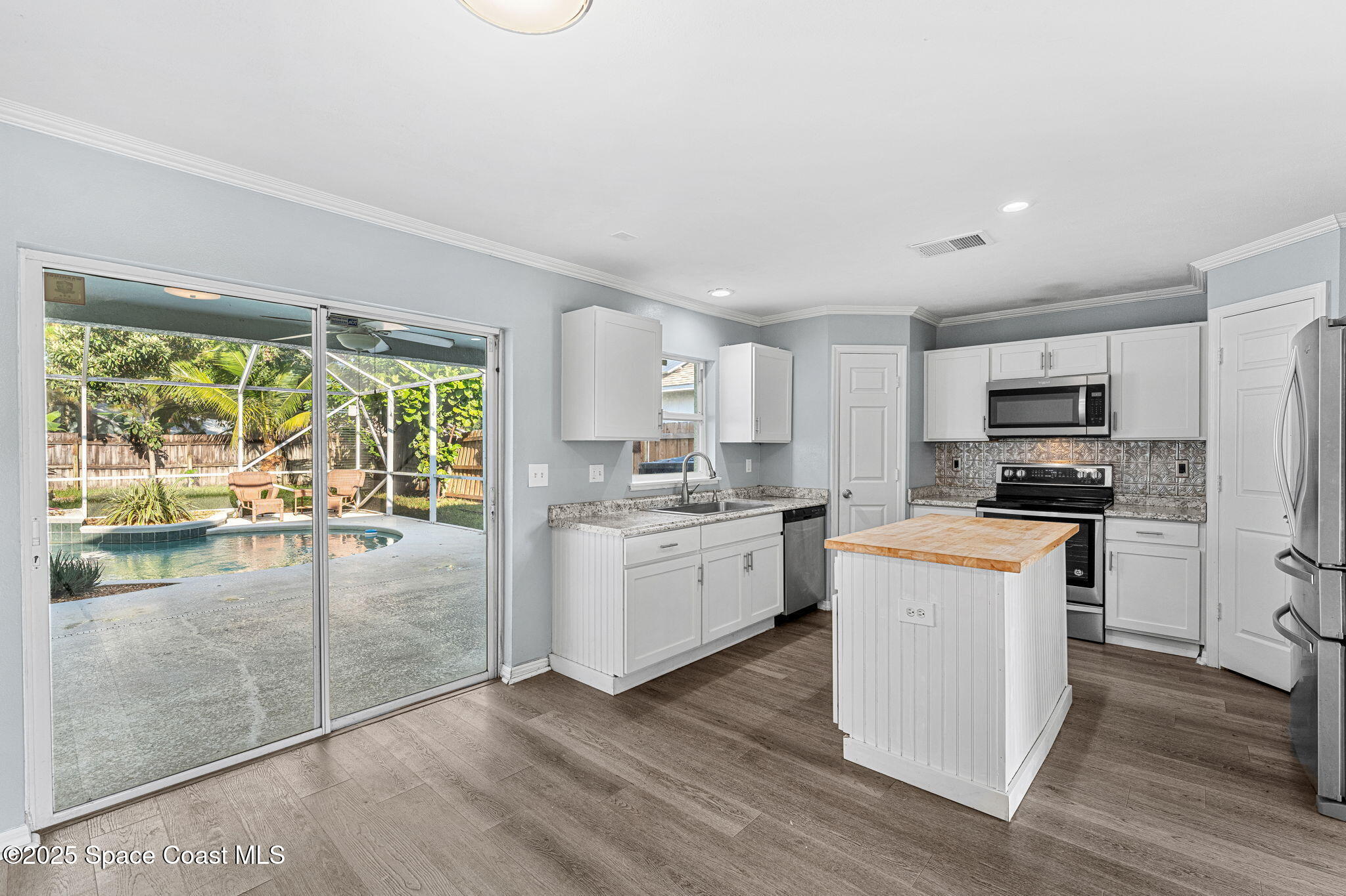 1249 White Oak Circle Melbourne, FL 32934 - Photo 6 of 34 a kitchen with white cabinets and appliances