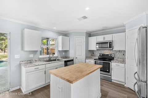 a kitchen with stainless steel appliances a stove sink microwave and cabinets