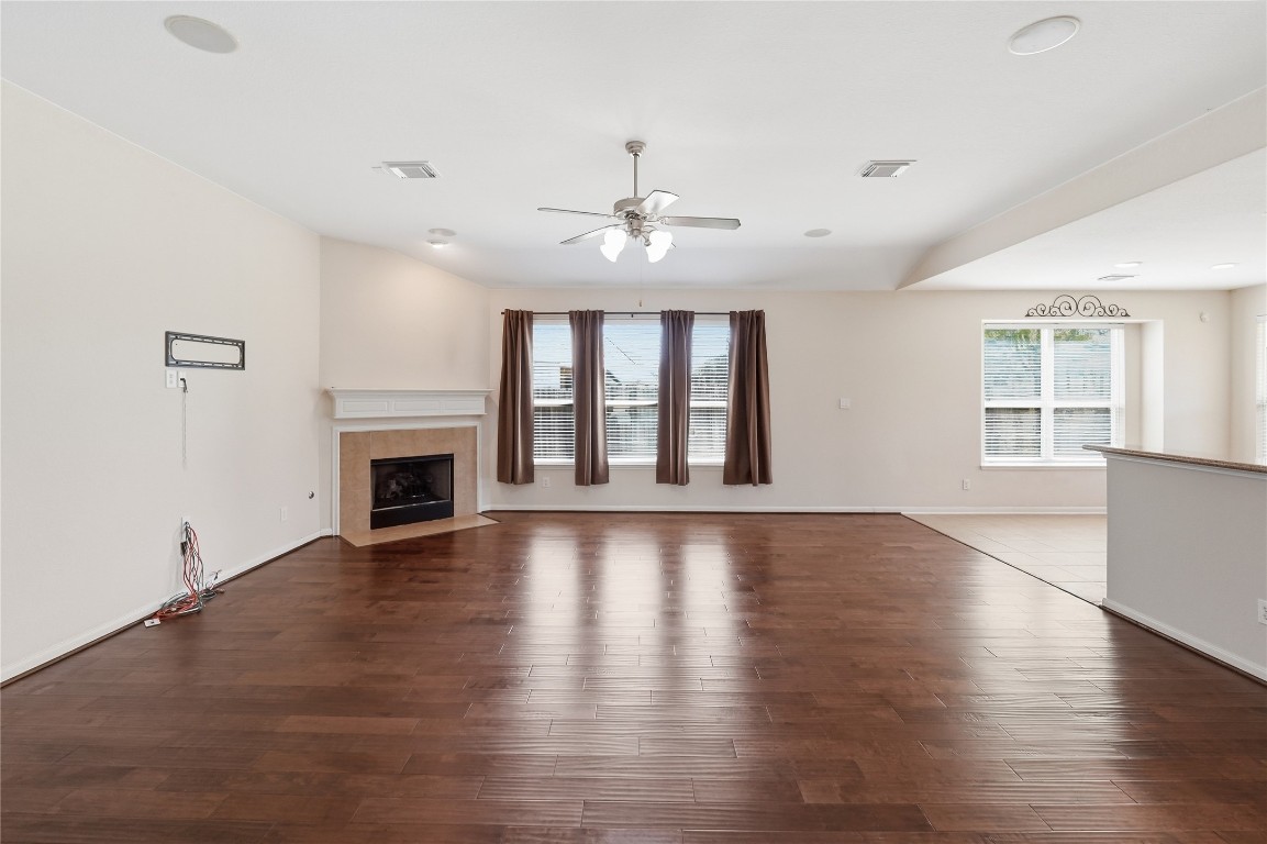 5803 Deleon Trail Drive Spring, TX 77379 - Photo 11 of 33 an empty room with wooden floor fireplace and windows