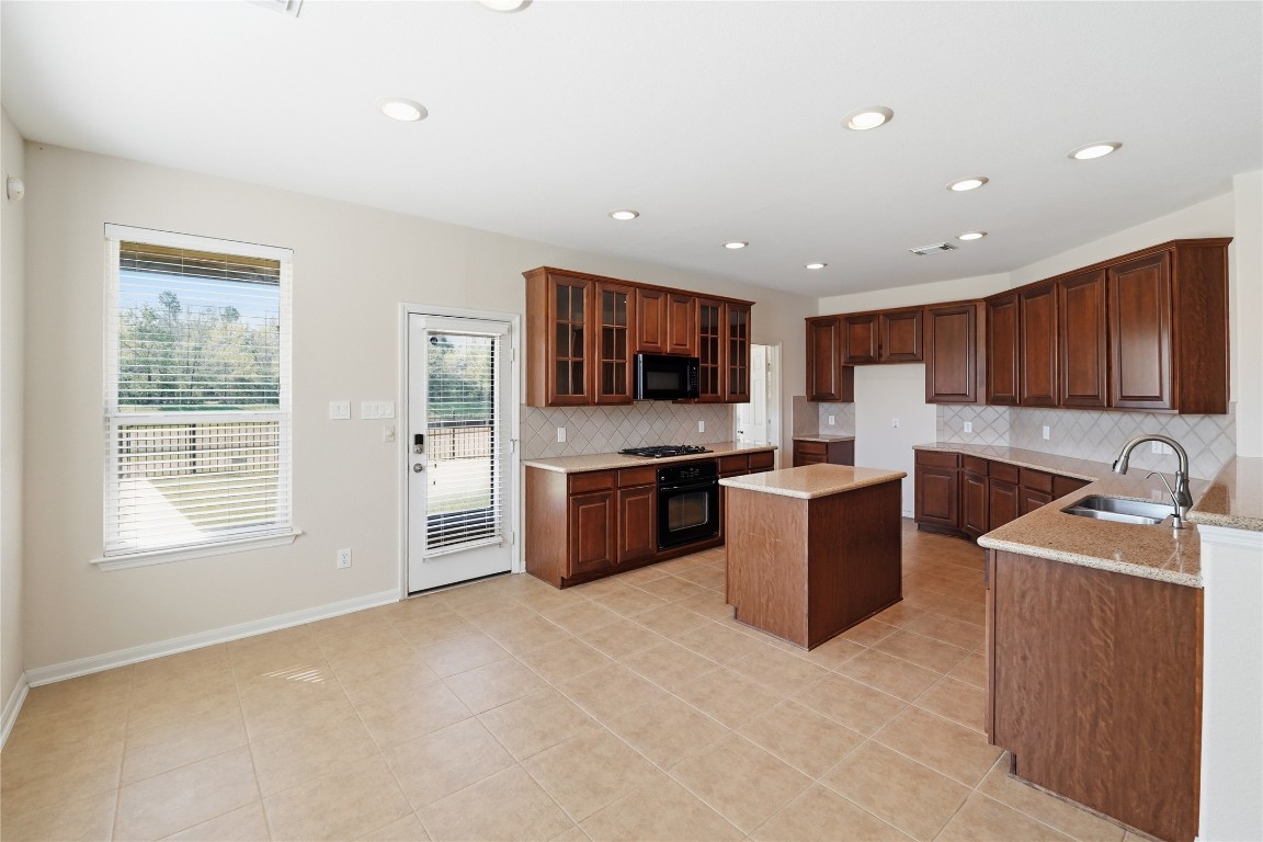 5803 Deleon Trail Drive Spring, TX 77379 - Photo 2 of 33 a large kitchen with stainless steel appliances granite countertop a stove a sink a refrigerator a microwave and cabinets