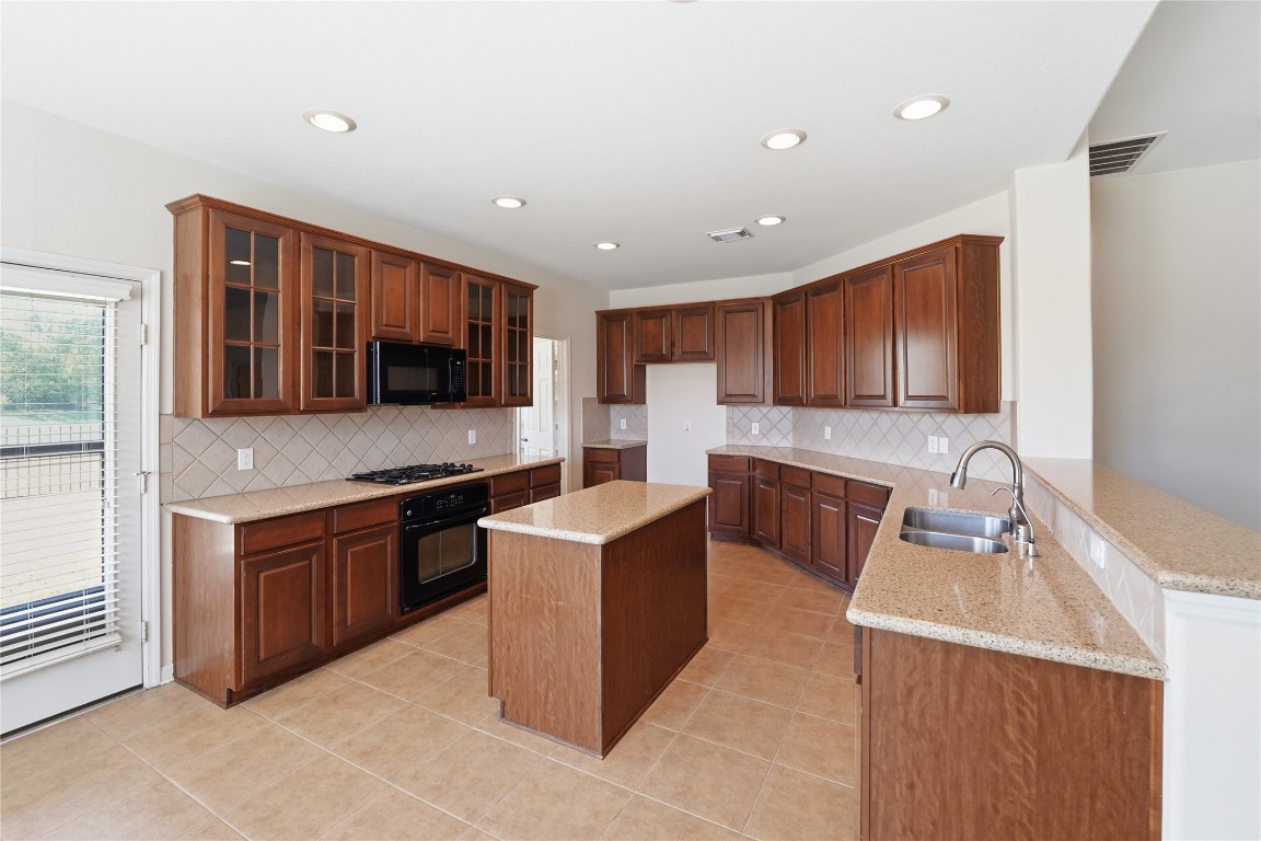 5803 Deleon Trail Drive Spring, TX 77379 - Photo 4 of 33 a kitchen with stainless steel appliances granite countertop wooden cabinets a sink and a stove