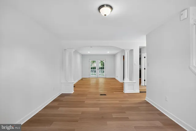 a view of empty room with wooden floor