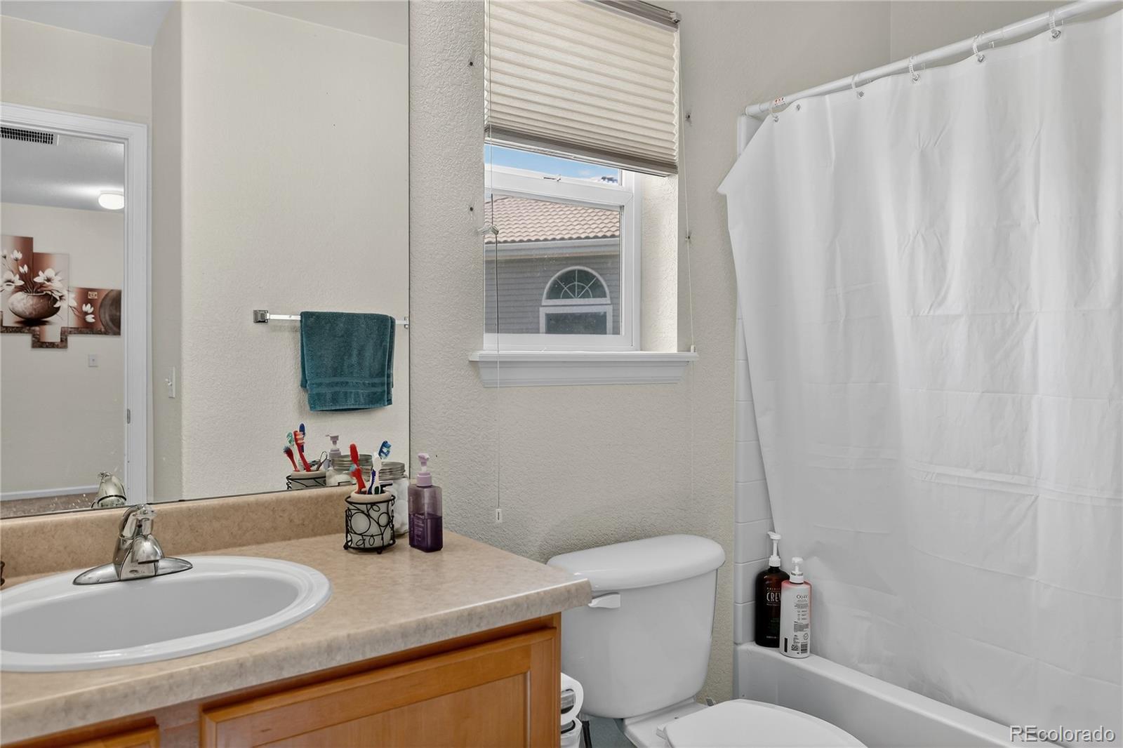 20000 East Mitchell Place, Unit 71 Denver, CO 80249 - Photo 11 of 28 a bathroom with a sink a toilet and mirror