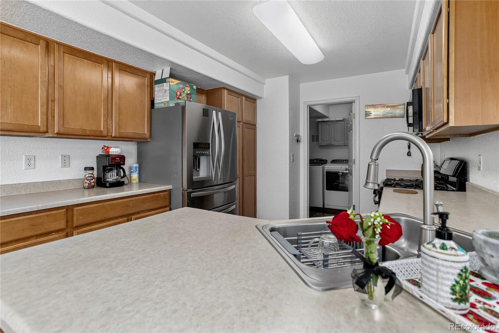 20000 East Mitchell Place, Unit 71 Denver, CO 80249 - Photo 15 of 28 a kitchen with stainless steel appliances kitchen island granite countertop a sink refrigerator and cabinets