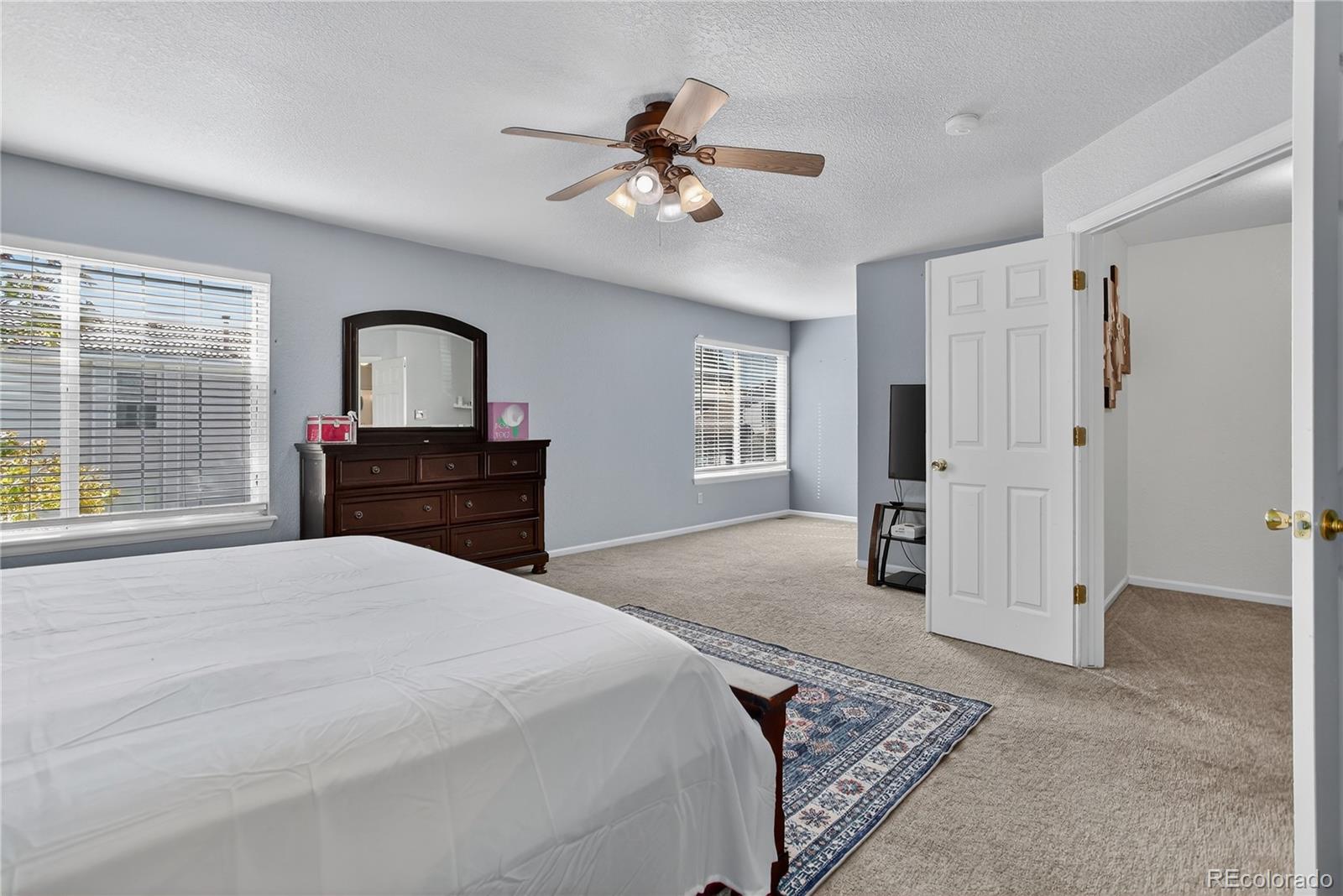 20000 East Mitchell Place, Unit 71 Denver, CO 80249 - Photo 18 of 28 a spacious bedroom with a large bed a chandelier and dresser