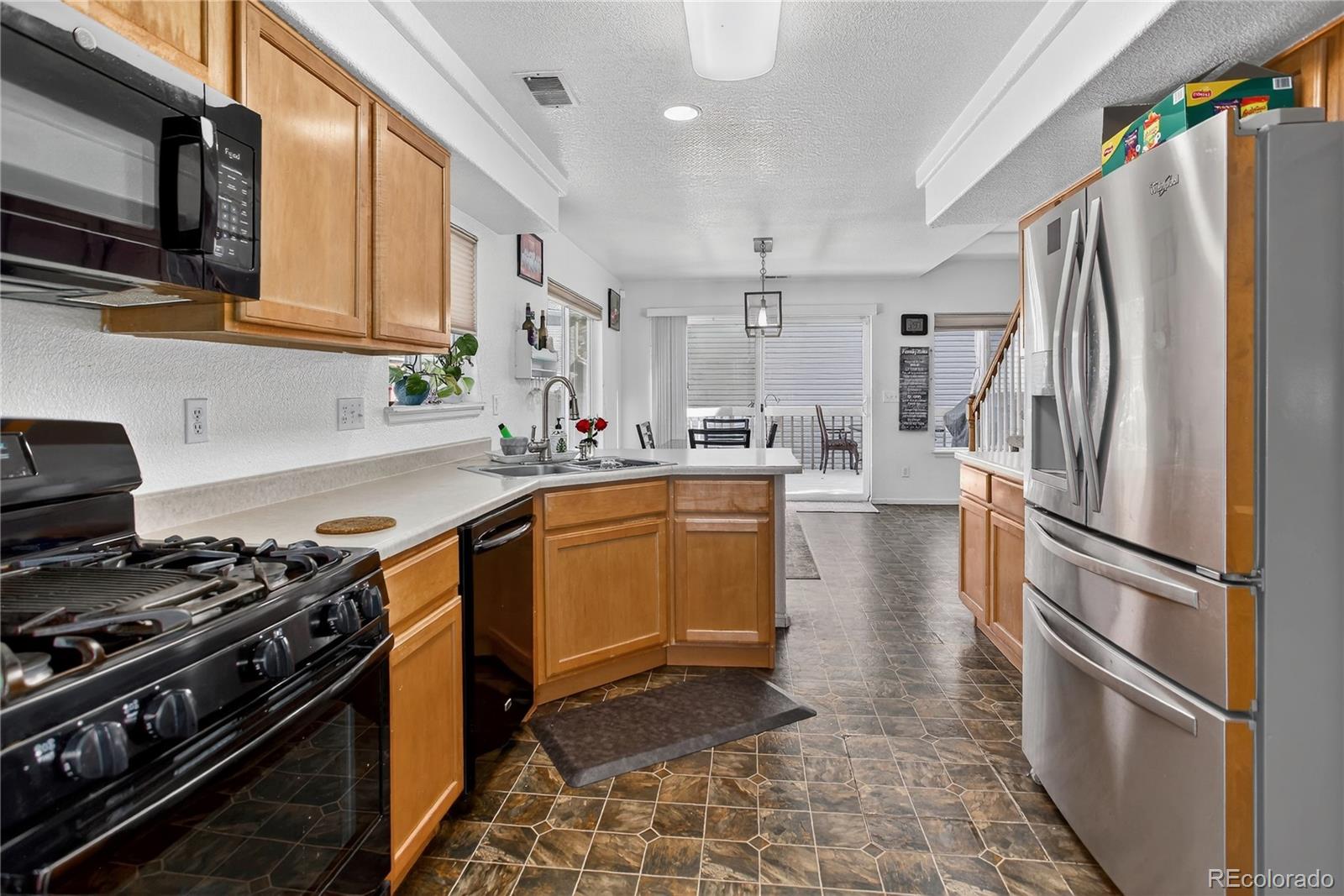 20000 East Mitchell Place, Unit 71 Denver, CO 80249 - Photo 7 of 28 a kitchen with stainless steel appliances granite countertop a refrigerator stove and sink