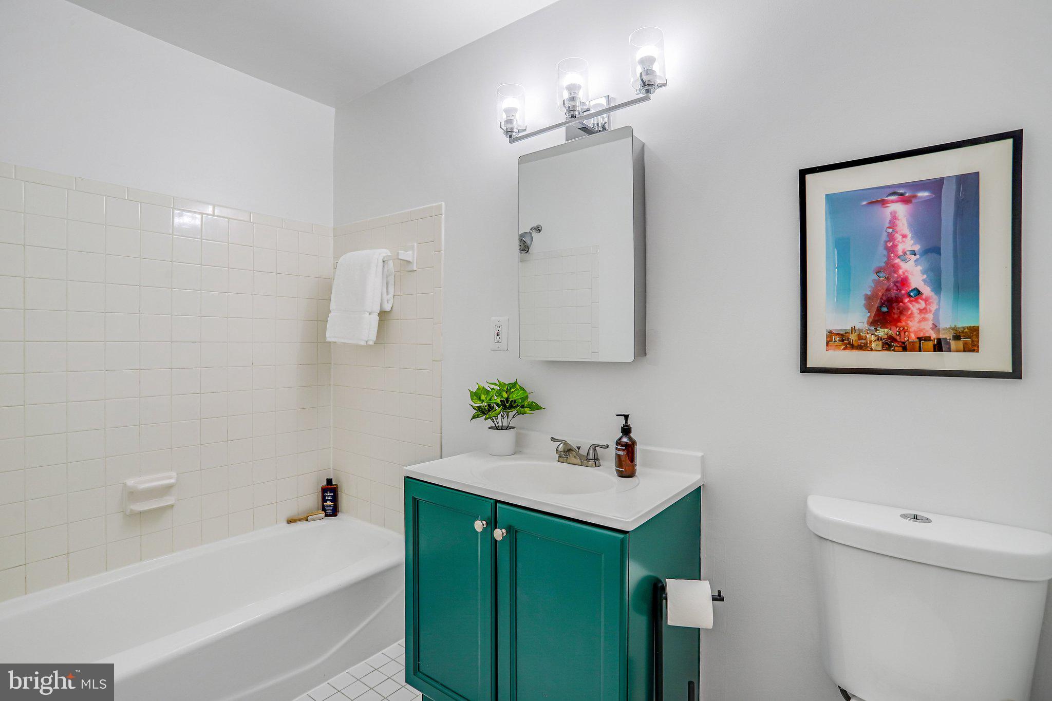 3420 16th Street Northwest, Unit 102 Washington, DC 20010 - Photo 17 of 18 a bathroom with a sink mirror vanity and toilet
