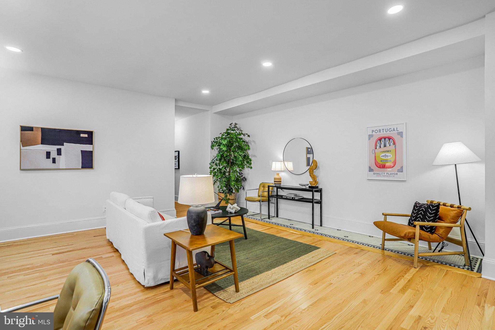 3420 16th Street Northwest, Unit 102 Washington, DC 20010 - Photo 5 of 18 a living room with furniture a rug and a potted plant
