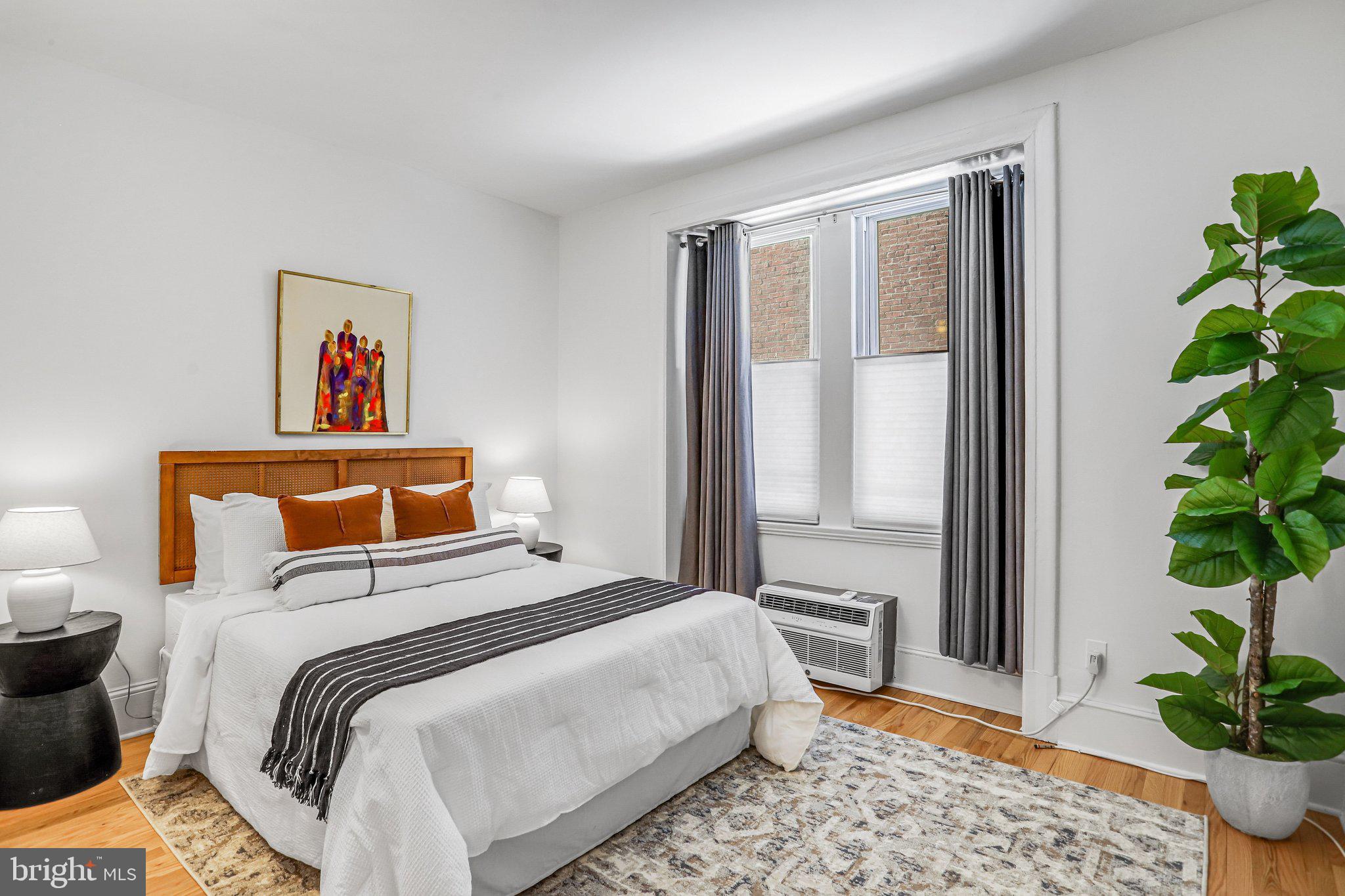 3420 16th Street Northwest, Unit 102 Washington, DC 20010 - Photo 9 of 18 a bedroom with a large bed and a potted plant