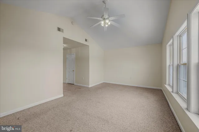 an empty room with a ceiling fan and a window