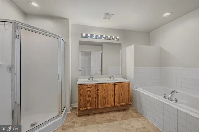a bathroom with a tub a sink and mirror