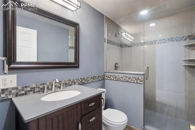 a bathroom with a sink a toilet a mirror and shower