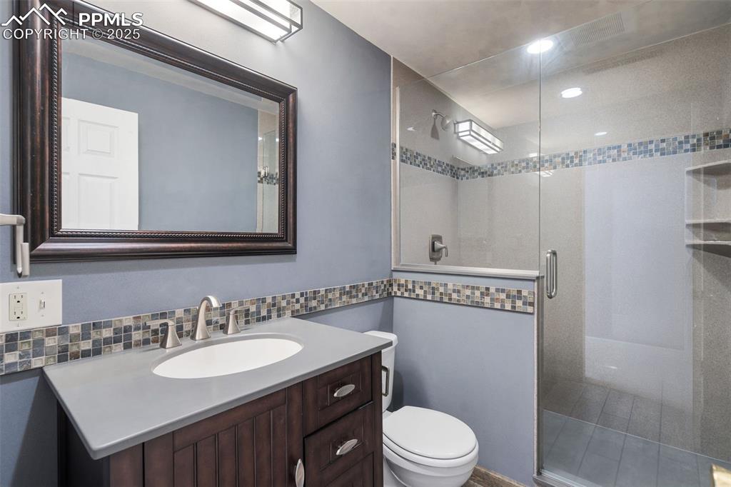 10 Haney Road Colorado Springs, CO 80906 - Photo 29 of 48 a bathroom with a sink a toilet a mirror and shower
