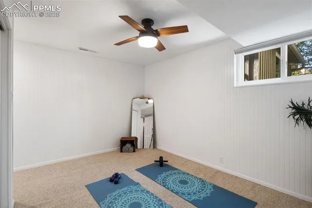 an empty room with a ceiling fan and window