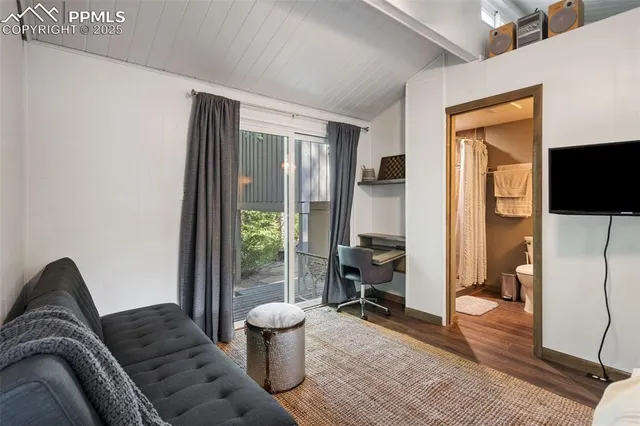 a living room with furniture a flat screen tv and a floor to ceiling window