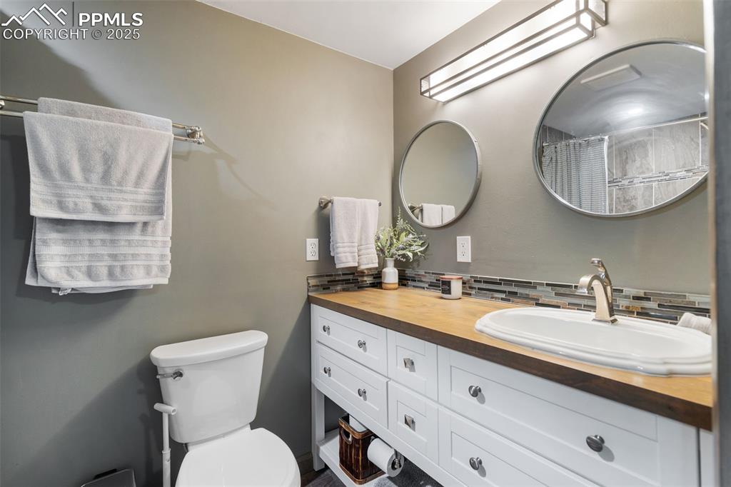 10 Haney Road Colorado Springs, CO 80906 - Photo 46 of 48 a bathroom with a granite countertop toilet a sink and a mirror