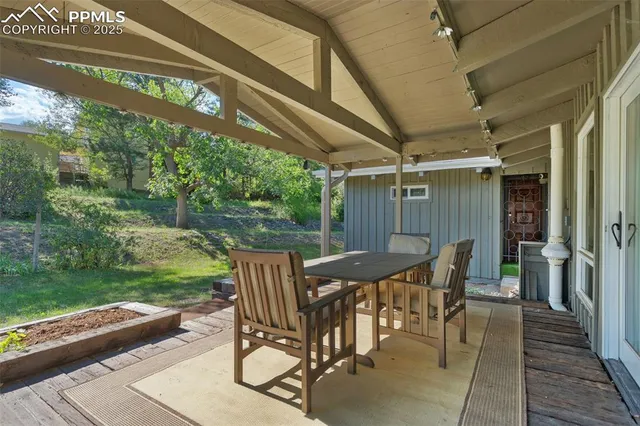 a view of a patio with table and chairs with wooden floor and fence