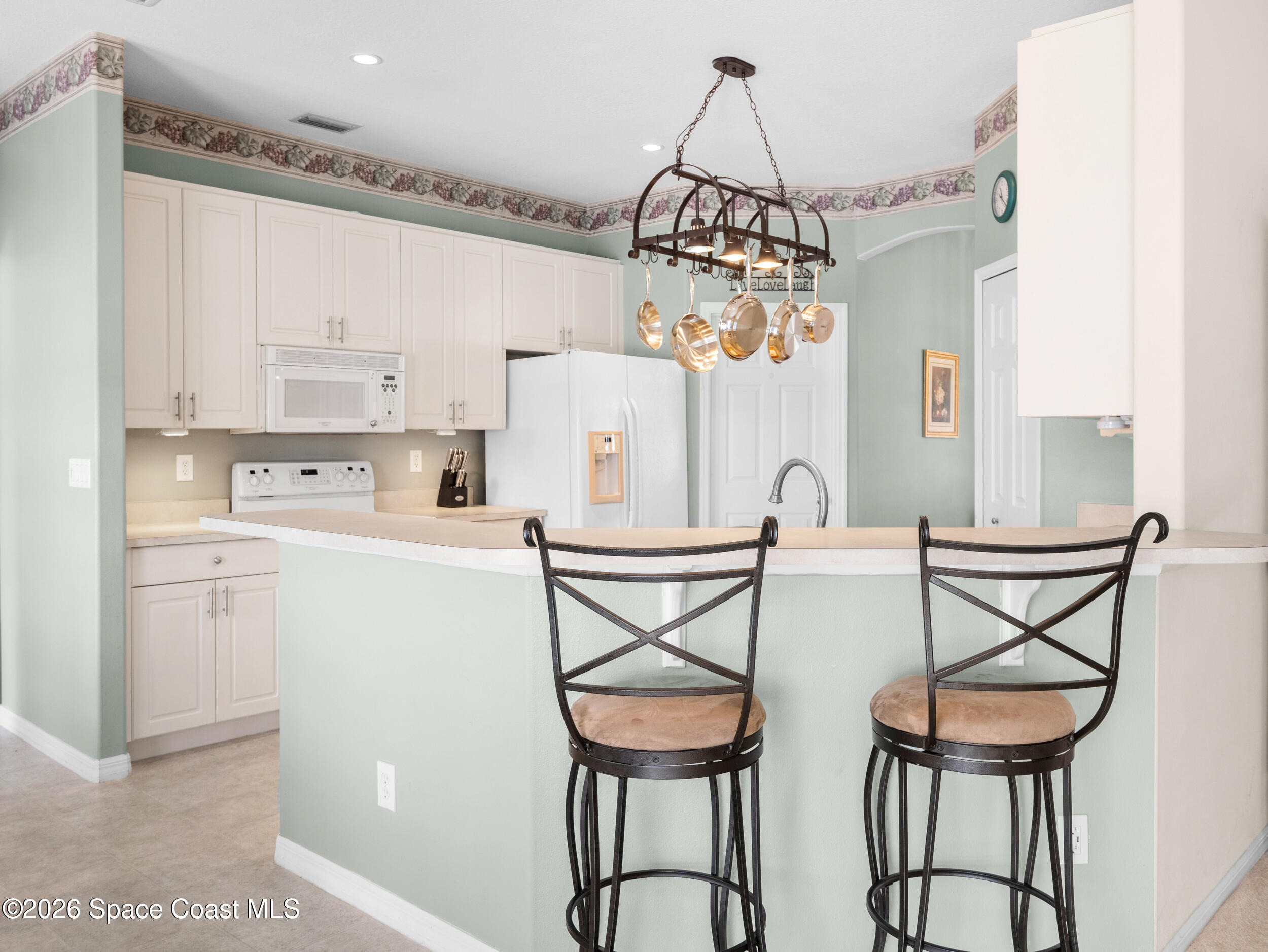 7429 Hackberry Road Cocoa, FL 32927 - Photo 20 of 51 a kitchen that has a cabinets a table and chairs in it