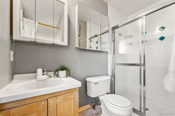 a bathroom with a sink a toilet and shower