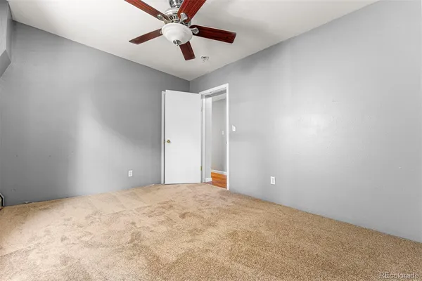 en empty room with ceiling fan and window