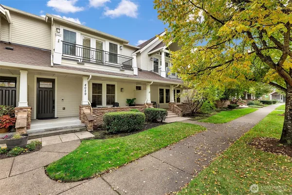 a front view of a house with a yard and potted plants
