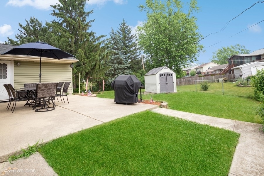 551 Ridge Circle Streamwood, IL 60107 - Photo 17 of 17 a view of a patio with a table and chairs under an umbrella