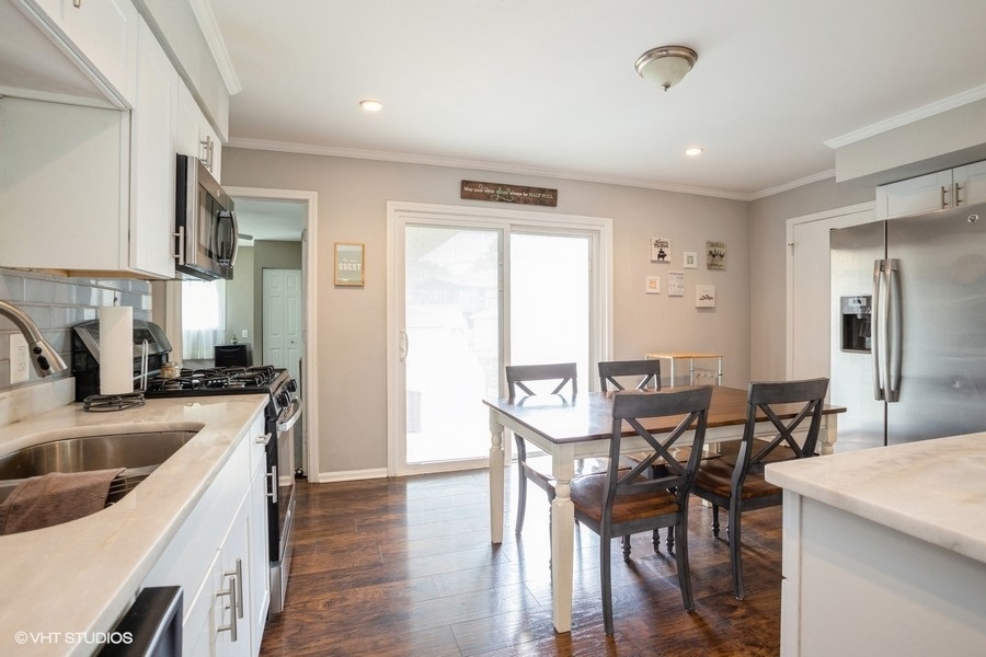 551 Ridge Circle Streamwood, IL 60107 - Photo 4 of 17 a kitchen with sink table and chairs