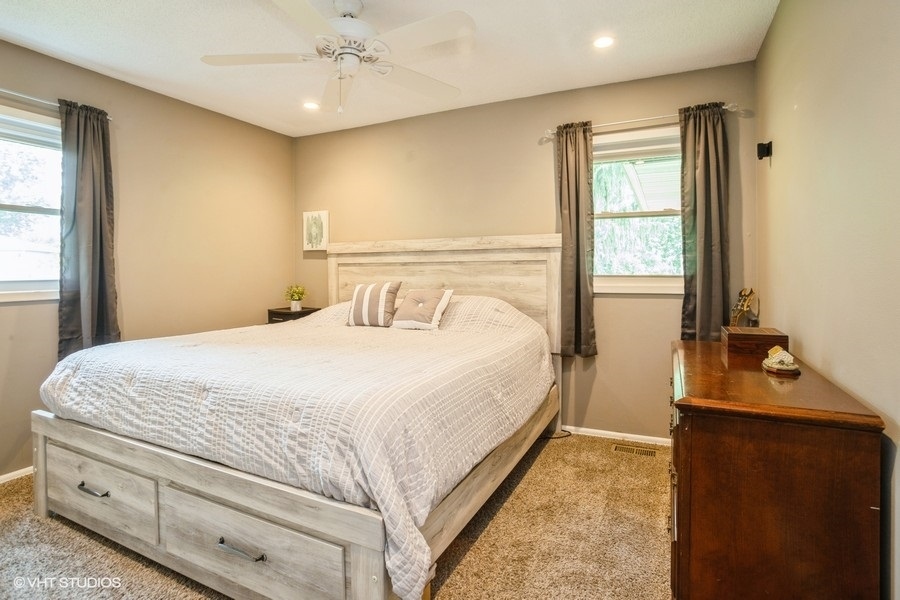 551 Ridge Circle Streamwood, IL 60107 - Photo 7 of 17 a bedroom with a bed and a chandelier