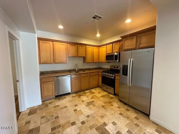 a kitchen with a refrigerator sink and cabinets