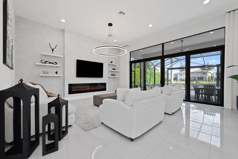 a living room with furniture a flat screen tv and a view of kitchen