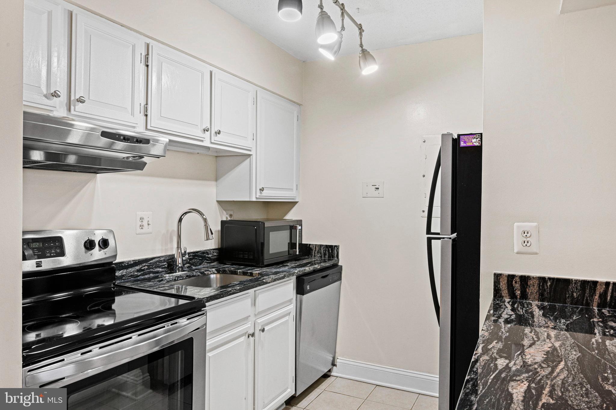 1808 Old Meadow Road, Unit 716 McLean, VA 22102 - Photo 6 of 36 a kitchen with stainless steel appliances a stove a refrigerator and cabinets