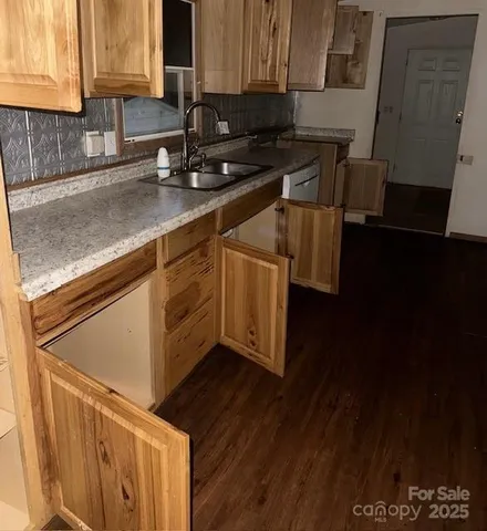 a kitchen with stainless steel appliances granite countertop a sink a stove wooden floor and cabinets
