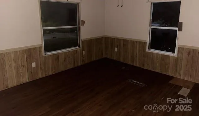 a view of a hallway with wooden floor and black cabinet