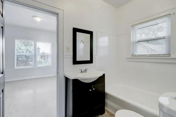 a bathroom with a toilet a sink and mirror