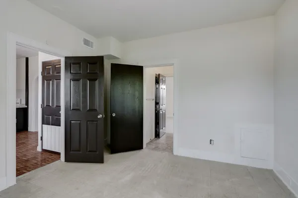 an empty room with closet and mirror