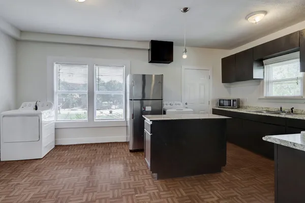 a kitchen with a sink and a stove top oven with wooden floor