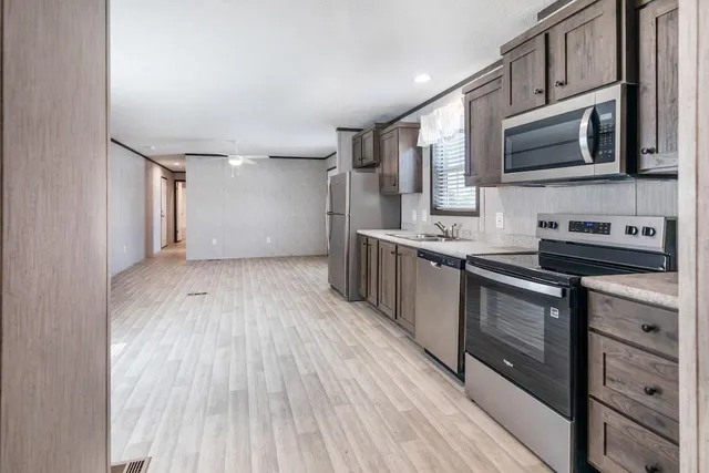 a kitchen with stainless steel appliances kitchen island granite countertop a sink stove and microwave
