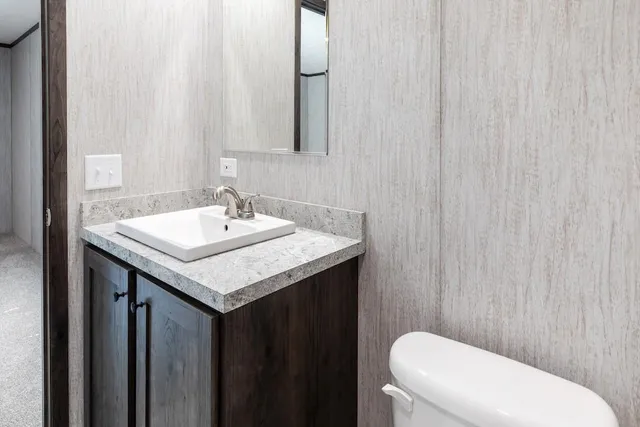 a bathroom with a sink a toilet and a mirror