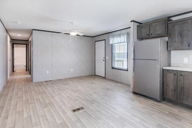 a view of a kitchen with a refrigerator and wooden floor
